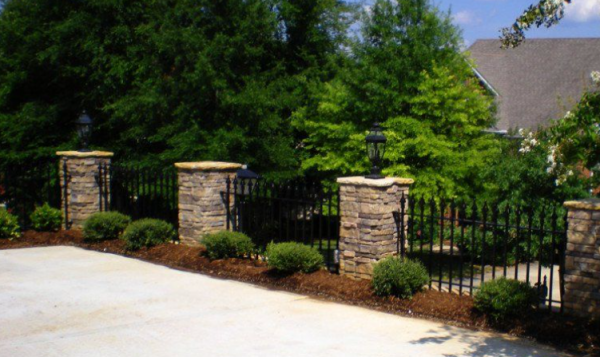 Pagar dengan kombinasi batu alam dan logam hitam